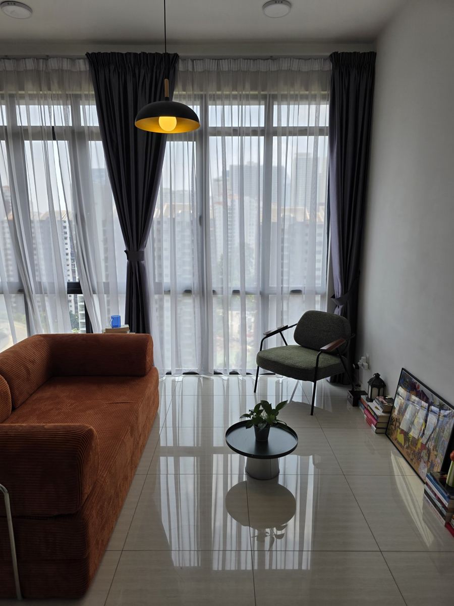 Session room in Kuala Lumpur with a sofa, armchair, and floor-to-ceiling windows