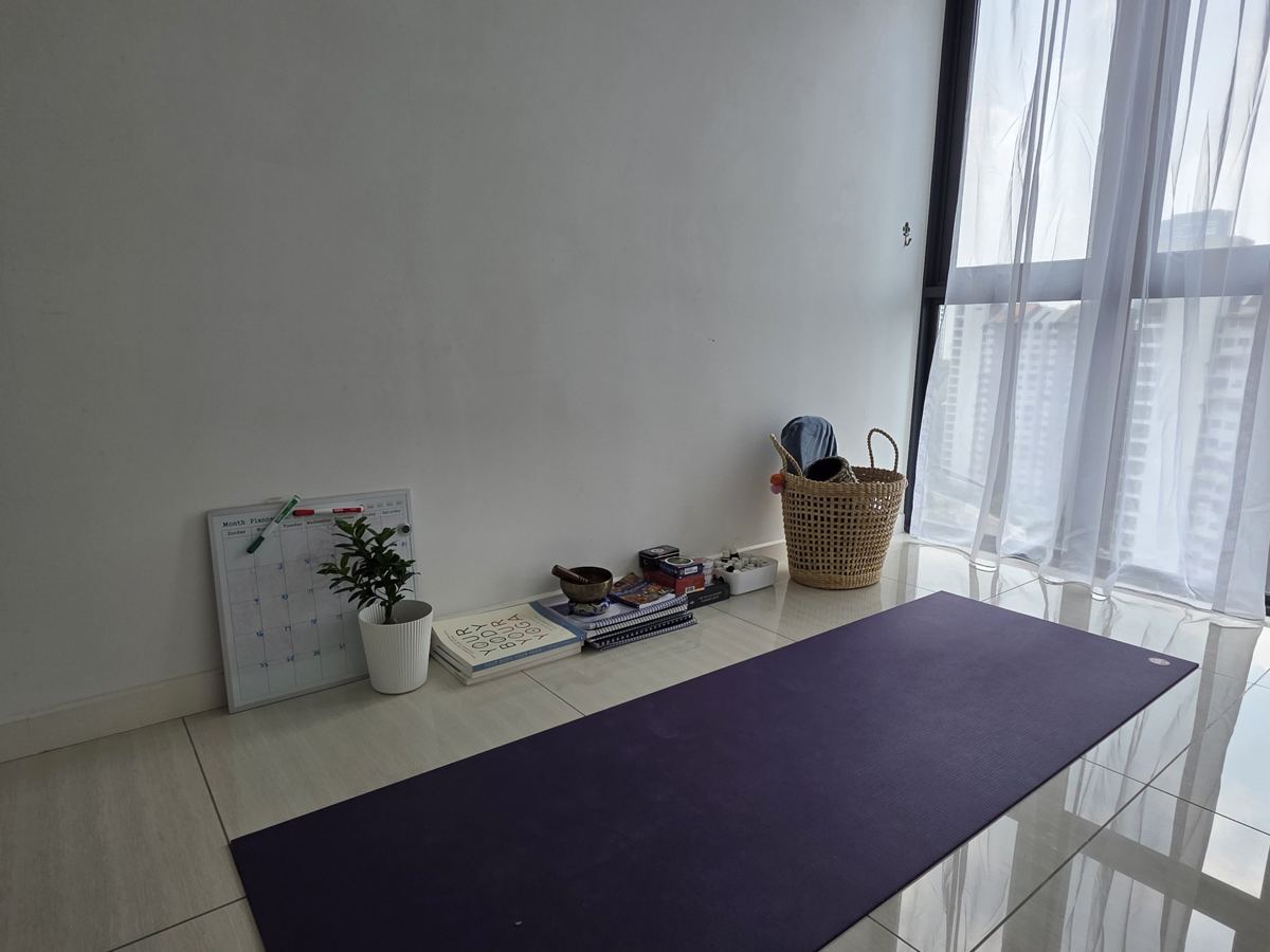 Yoga mat laid out beside a shelf of books and a singing bowl