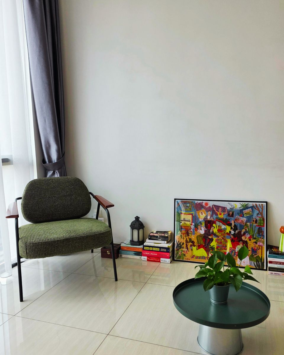 Seating corner in the session space with an armchair, plant, and books